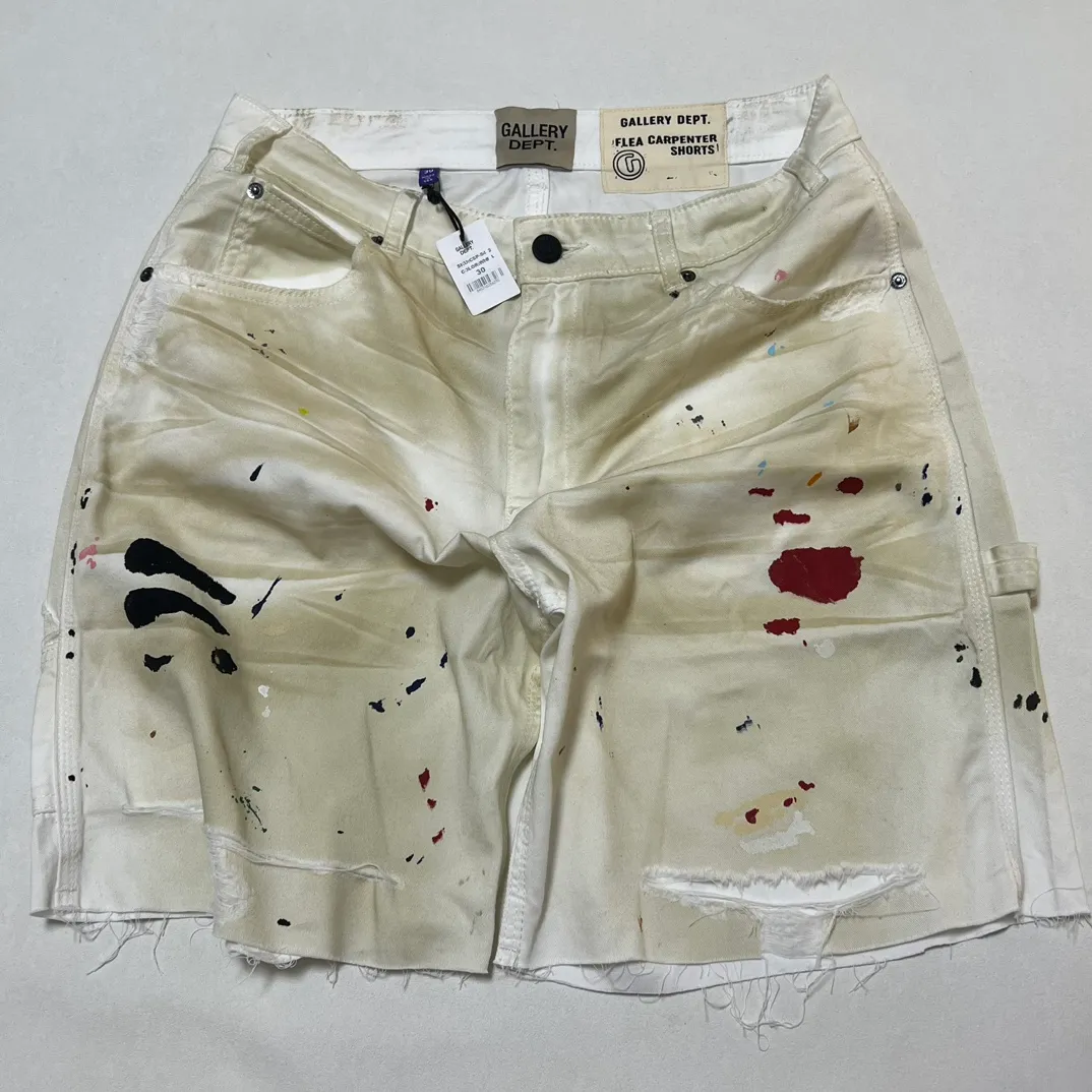 Close-up of details GALLERY DEPT. FLEA CARPENTER SHORTS Ink-splash knife-cut mud-dyed denim shorts Destroyed VINTAGE distressed denim shorts Distressed white S-XL Rewashed cement-dyed to make it distressed Knife cut holes and cat whiskers worn away Customized complete set of accessories with logo Handmade acrylic splash-ink graffiti